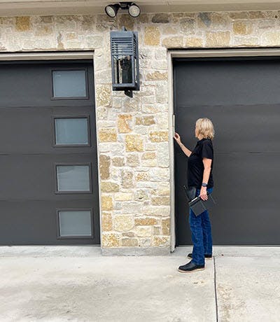 Home Watch professional checking garage door opener.