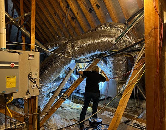 homewatcher inspecting air conditioner in  attic
