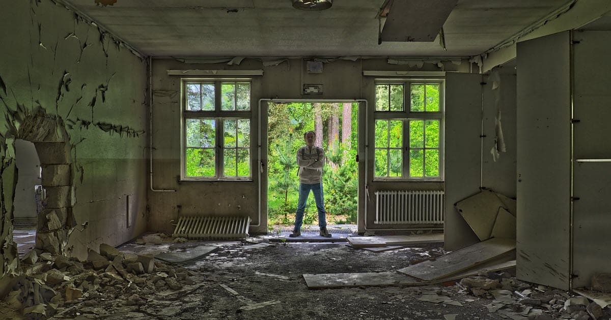 man standing in vandalized house