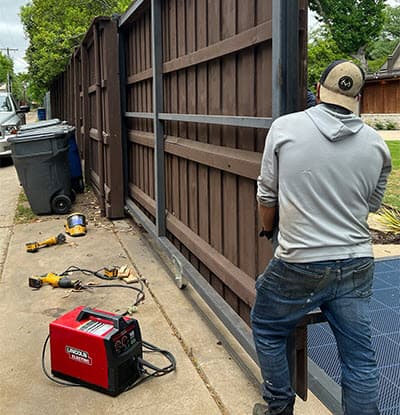 man manually pushing big gate