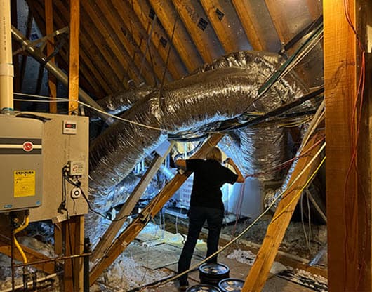 homewatcher inspecting air conditioner in attic